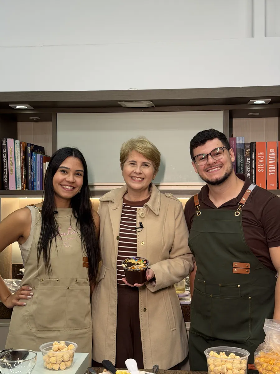 Thayna apresentando os baldes de pipoca gourmet Aboeta em um programa de televisão