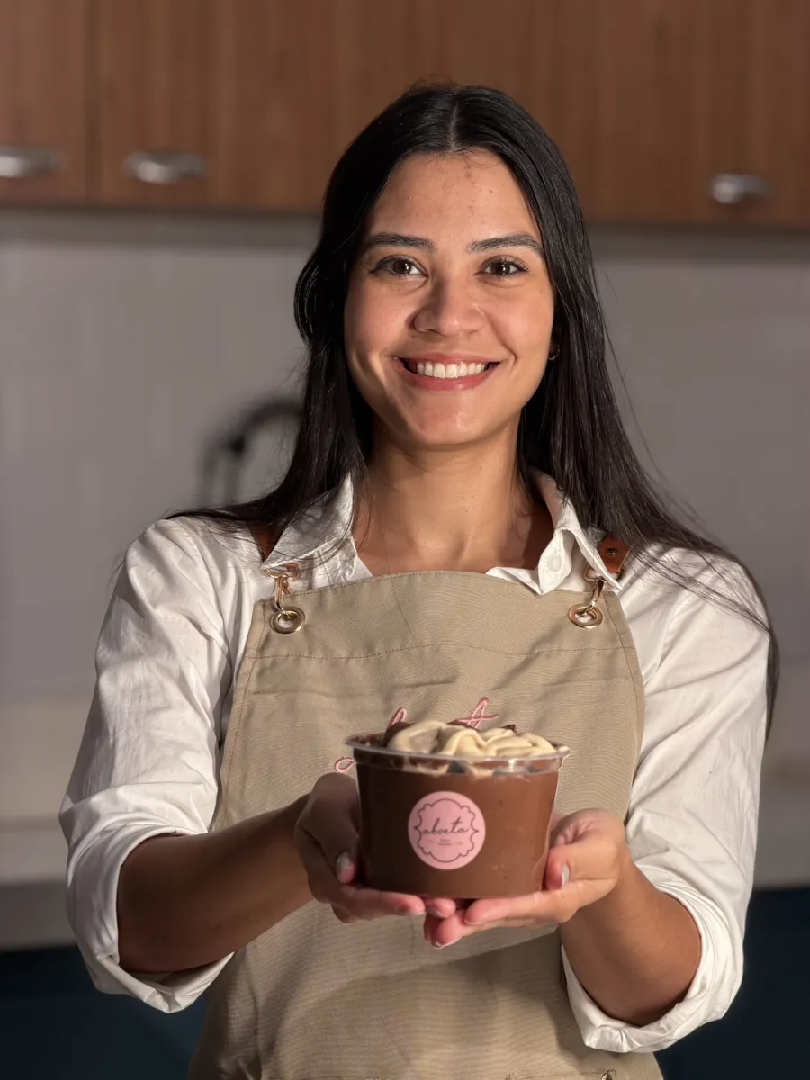 Thayna segurando um pote de pipoca gourmet artesanal da Aboeta
